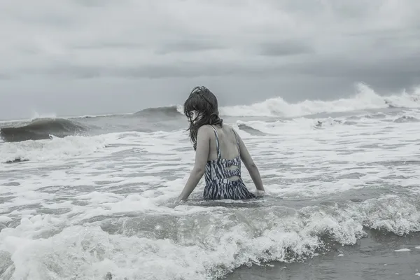 振り返ってみると野生の海に座って魅力的な女性 — ストック写真
