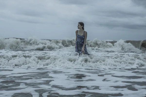 Young Female Model walking into ocean — Stok fotoğraf