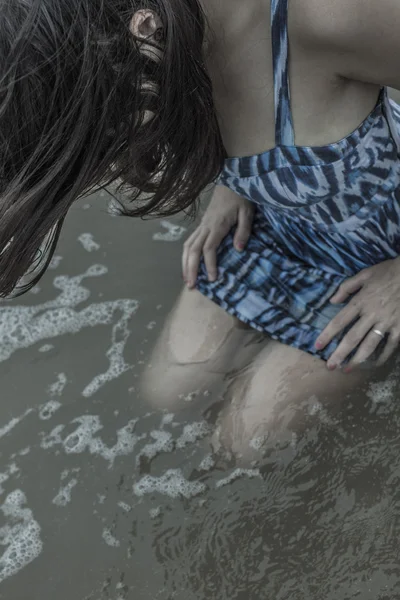 Modelo femenino sentado en el océano — Foto de Stock