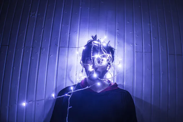 Male Model trying to Untangle Christmas lights — Stock Photo, Image