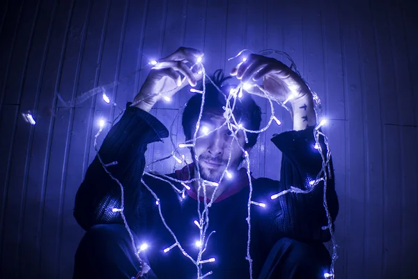 Young Man trying to Untangle Christmas lights — Stock Photo, Image