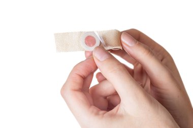 Kız elinde bacağında çekirdek nasırlarına karşı bir alçı tutuyor. Beyaz arkaplan, izole et