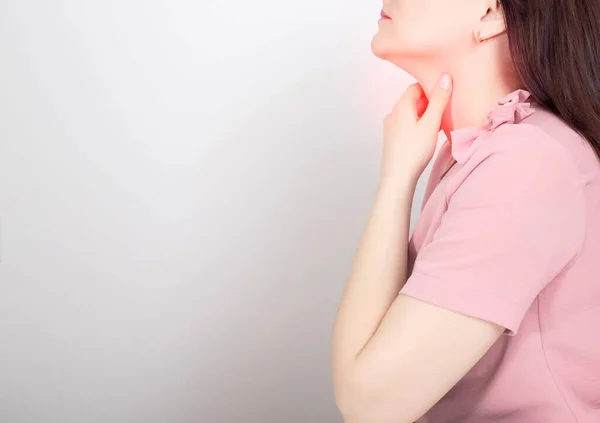 Schöne Brünette Mädchen Hält Ihre Kehle Auf Einem Weißen Hintergrund — Stockfoto