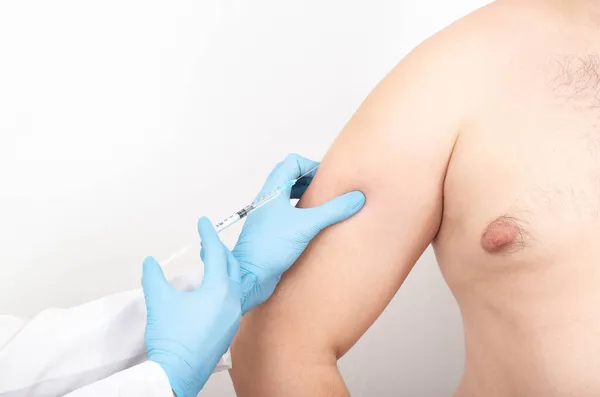 整形外科医は皮膚の弾力性のための人の腕に注射をする テキスト 三角形のためのコピースペース — ストック写真