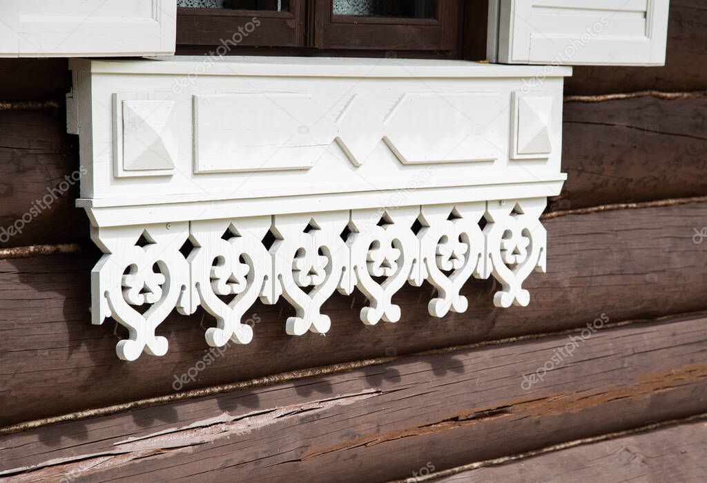 Beautiful carved window shutters in a log wooden house. Rural country house