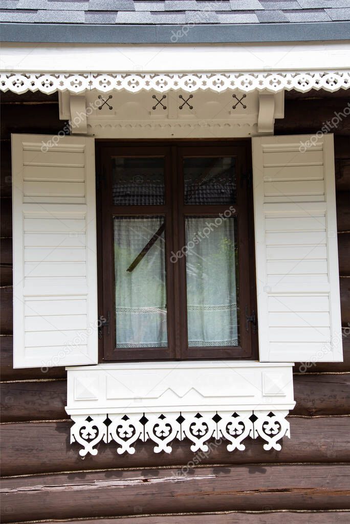 Beautiful carved window shutters in a log wooden house. Rural country house, close-up