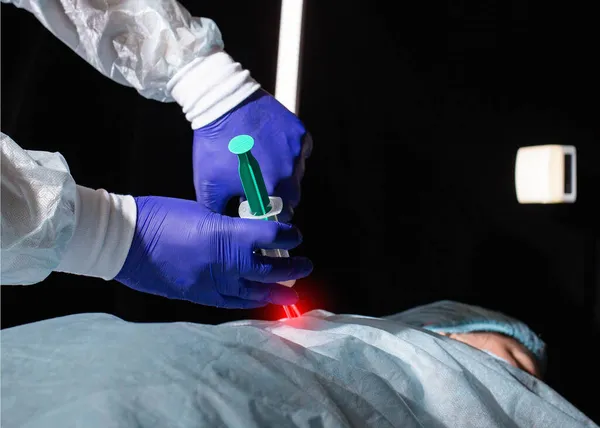 The doctor gives a medical block to a patient who has back pain and a pinched nerve. Modern minimally invasive procedure for the treatment of intervertebral hernias, plasma therapy