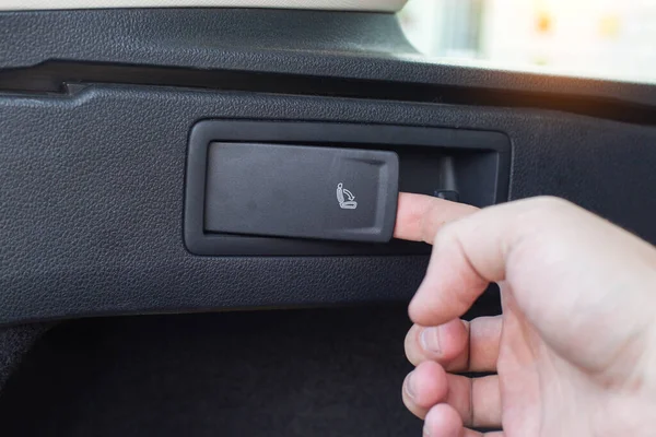 Button for folding and unfolding the rear row of seats in a passenger car, close-up — Stock Photo, Image
