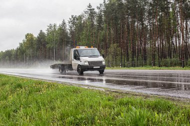 Bir araba çekicisi yağmurlu bir havada ıslak bir yolda çağrı yapar. Yardım yolda.
