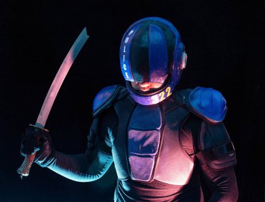 Robot polis kısa samuray kılıcını çıkarıp sallıyor, dumanla, dumanla karanlıkta duruyor. Halfman kameraya bakıyor. Gelecekçi bilim kurgu sahnesi. Kırmızı mavi ışık yanıp sönüyor. Hukuk ve Düzen kavramı. Yarının dünyası. Robocop gibi, Yargıç Dredd, beşinci. 