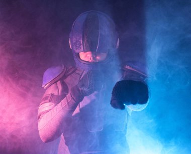 Erkek robot polis dalgaları ve karanlıkta yumrukları. Halfman dövüşmeye hazır. Biyonik sayborg kameraya bakıyor. Kırmızı mavi ışık. Hukuk ve Düzen kavramı. Yarının dünyası. Portre