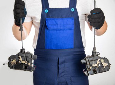 Bir oto elektrikçi merkezi araba kapısını elinde tutuyor. Bir araba servisinde elektrikçilerin tamir ve değiştirme kavramı.