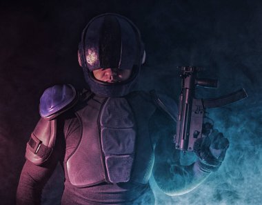 Siber punk konsepti, gelecekteki dünya. Karanlıktaki polis memuru, yarı insan biyonik cyborg ya da silahı dolduruyor, kolu seğiriyor, karanlıkta kameraya bakıyor. Bilim kurgu sahnesi, bilim..