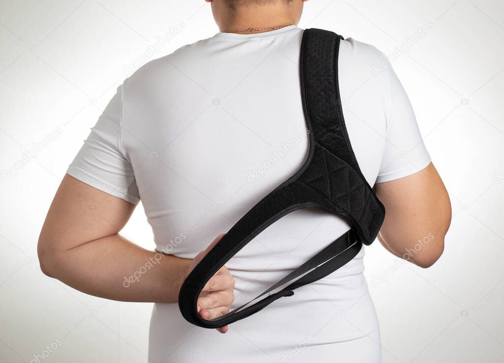 A male is wearing an orthopedic posture corrector. Treatment for stoop and back problems
