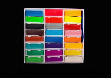 Siyah zemin üzerinde çok renkli plastikler olan kutuyu aç. Yakın çekim, anaokulu.