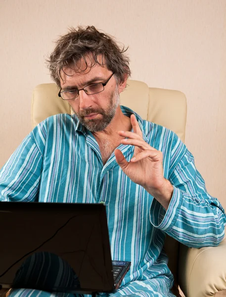 Homme assis dans la chaise avec ordinateur portable — Photo