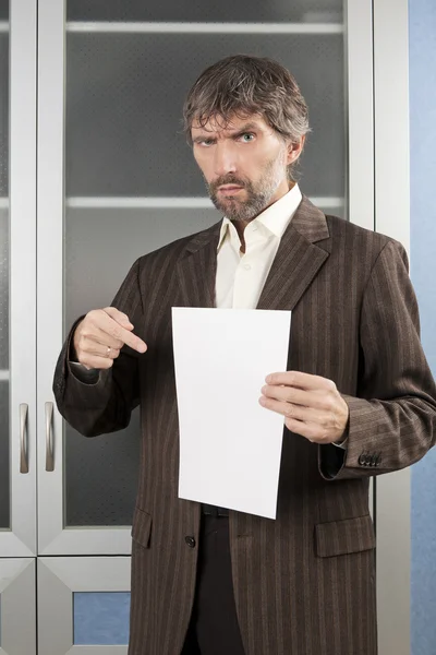 Un homme en colère montre une feuille de papier blanc — Photo