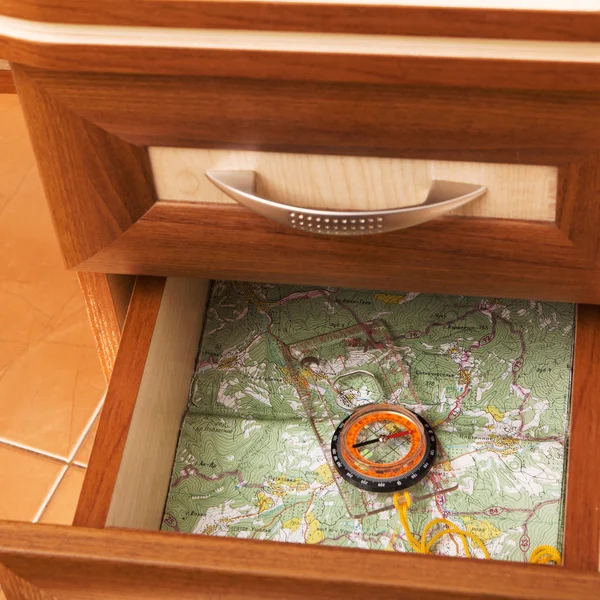 地图和指南针在打开办公桌的抽屉里 — 图库照片