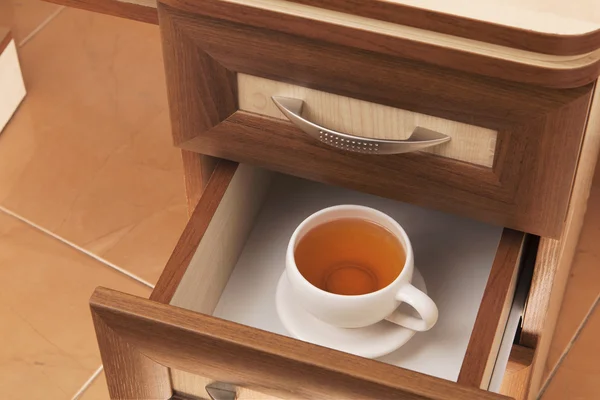 Cup of tea in desk drawer — Stock Photo, Image