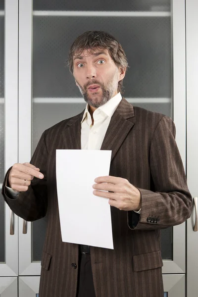 Surprised man shows blank sheet of paper — Stock Photo, Image