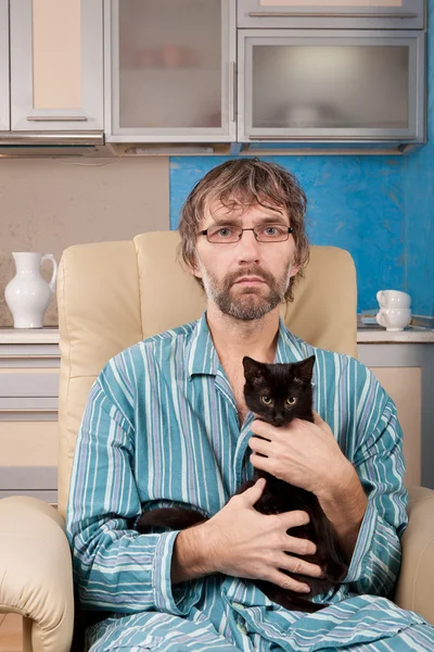 Man sitting in chair with kitten — Stock Photo, Image