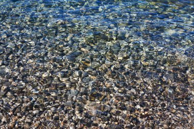 temiz deniz suyunun altında çakıl taşları