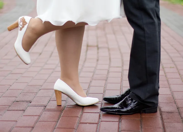 Zapatos de una novia y un novio caminando por la ciudad del pavimento —  Fotos de Stock