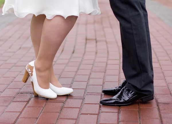 Zapatos de una novia y un novio caminando por la ciudad del pavimento —  Fotos de Stock