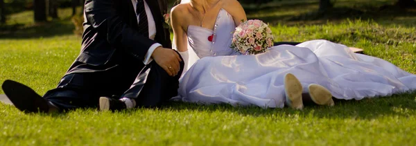 Happy couple are sitting on the green grass — Stock Photo, Image