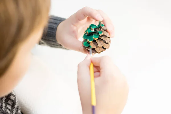 新年の工芸品 子供は松のコーンを描いている — ストック写真