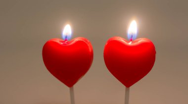 Two candles in the form of a heart. Are burning.