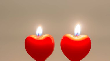 Two candles in the form of a heart. Are burning.