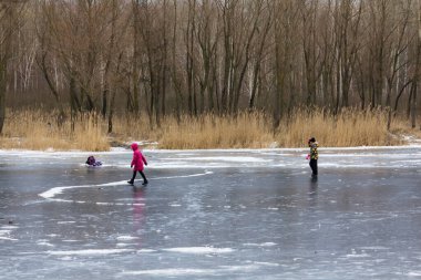 Aptal insanlar Kiev 'deki bir gölde ince buzda kayıyorlar.