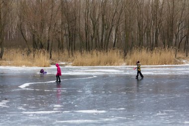 Aptal insanlar Kiev 'deki bir gölde ince buzda kayıyorlar.