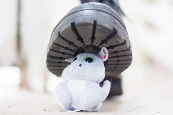 Army boot steps on a child\'s toy. War in Ukraine, destruction of the civilian population