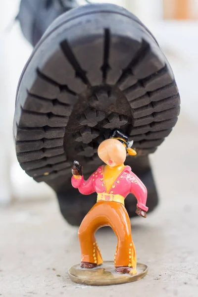 Army boot steps on a child's toy. War in Ukraine, destruction of the civilian population