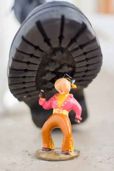 Army boot steps on a child's toy. War in Ukraine, destruction of the civilian population