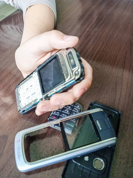 Child Dismantles Phone Repair — стоковое фото