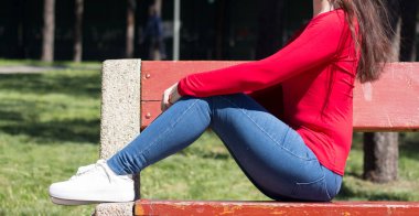 Kız baharda bankta dinleniyor.