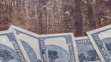 100 dolarlık banknotlar kahverengi bir masaya dizilmişti.
