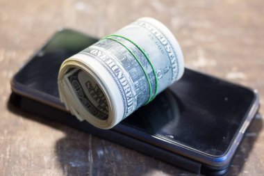 Cep telefonundaki para banknotları. Ukrayna 'daki savaş nedeniyle fiyatlarda artış