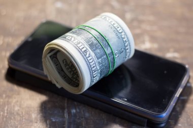 Cep telefonundaki para banknotları. Ukrayna 'daki savaş nedeniyle fiyatlarda artış