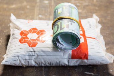 Bir paket kaya tuzu üzerinde para banknotları. Ukrayna 'daki savaş nedeniyle fiyatlarda artış