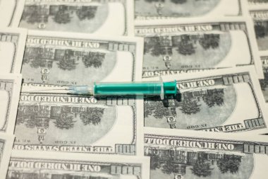Banknotların üzerinde tıbbi şırınga. Ukrayna 'daki savaş nedeniyle tıbbi bakım maliyetlerindeki artış