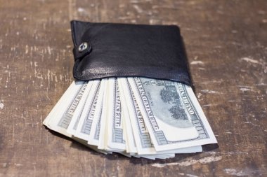Kahverengi bir masanın üzerinde banknotlar olan cüzdan. Ukrayna 'daki savaşla ilgili hizmetlerin maliyetinde artış
