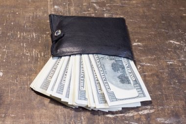 Kahverengi bir masanın üzerinde banknotlar olan cüzdan. Ukrayna 'daki savaşla ilgili hizmetlerin maliyetinde artış