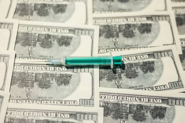 Medical syringe on banknotes. The rise in the cost of medical care due to the war in Ukraine