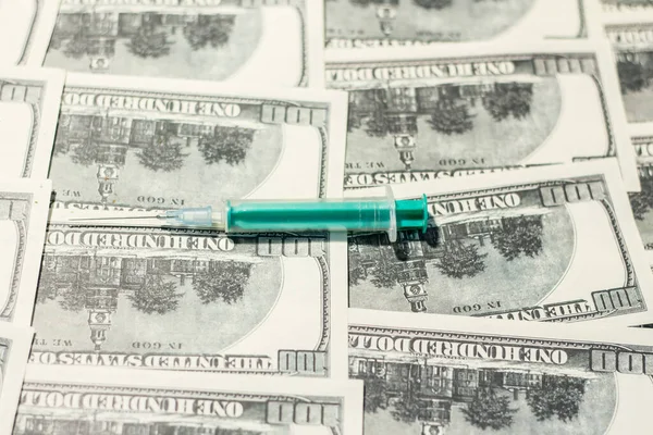 Medical syringe on banknotes. The rise in the cost of medical care due to the war in Ukraine