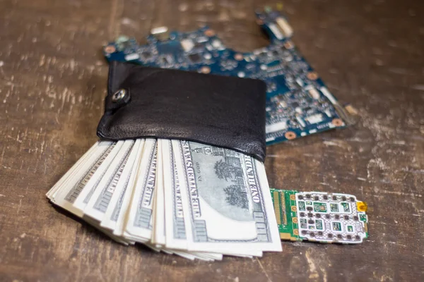 Purse with banknotes on motherboards. The rise in price of electronics in connection with the war in Ukraine