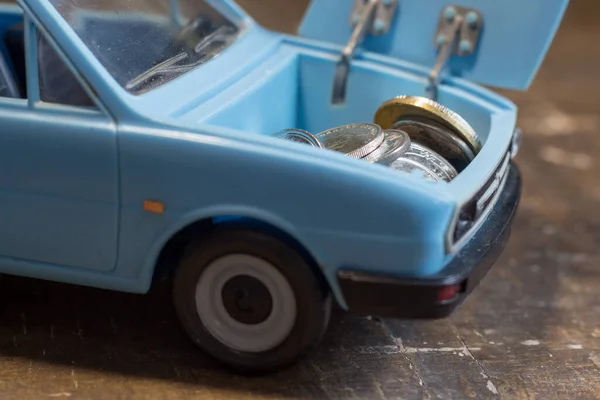 Money in the trunk of a children\'s toy car. Rise in the cost of fuel due to the war in Ukraine